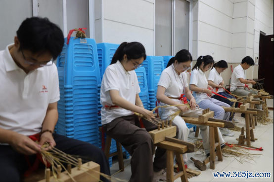 在红色民俗体验课堂上,实践团成员学习编织红军草鞋。学校供图